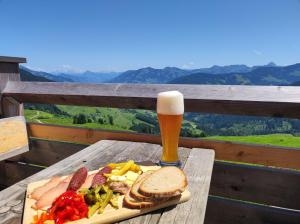 a table with a plate of food and a glass of beer at Chalet zum Feldalphorn Prädasten WILD605 in Schwarzenau