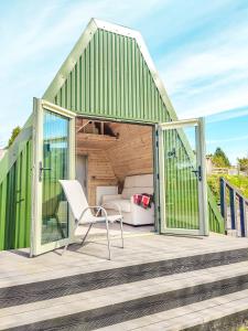 a green house with a white chair on a deck at Bective Mill Glamping & Camping 
