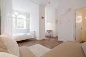 a white room with a bed and a window at St. Lukes View, Shoreditch, by the Design Traveller in London