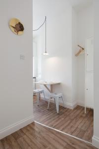 a white room with a table and a desk at St. Lukes View, Shoreditch, by the Design Traveller in London