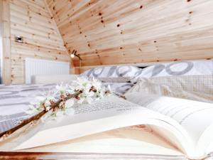 an open book on a bed with flowers on it at Bective Mill Glamping & Camping 