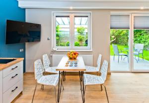 a kitchen and dining room with a table and chairs at Domek przy promenadzie in Kołobrzeg