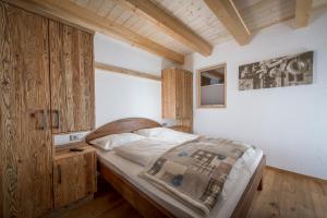 um quarto com uma cama e um armário de madeira em Au Hochalm Chalet em Söll