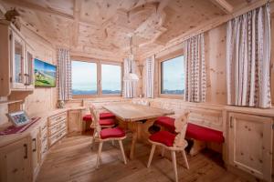 uma sala de jantar com uma mesa de madeira e cadeiras em Au Hochalm Chalet em Söll