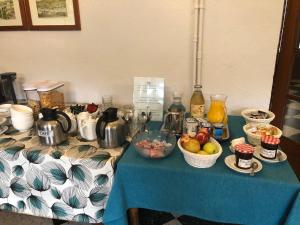 une table avec un chiffon bleu et des bols de fruits dans l'établissement Hôtel Le Val Du Tech, à Prats-de-Mollo-la-Preste