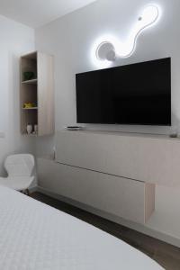 a bedroom with a flat screen tv on a wall at Regina's home in Bari