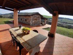 einen Tisch und Stühle auf einer Terrasse mit einem Steingebäude in der Unterkunft Villa Saturnia in Saturnia