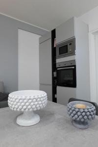 a white kitchen with a table and a microwave at Regina's home in Bari