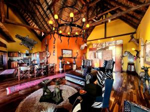 a living room with a couch and a chandelier at Phumelo Lodge in Bela-Bela