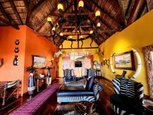 a living room with a couch and a chandelier at Phumelo Lodge in Bela-Bela