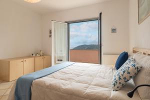 a bedroom with a bed and a large window at Bike e Relax Villa in Bardino Vecchio