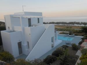 ein weißes Haus mit Pool und Meer in der Unterkunft Grand Villa Lino in Skyros