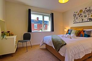 a bedroom with a bed with a chair and a window at Causey Lodge superb comfy home in Exeter by StayStay in Exeter