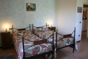 カスティリオーネ・シュル・ラーゴにあるVilla Il Cedroのベッドルーム1室(ベッド2台、ナイトスタンド2台付)