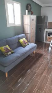 a living room with a blue couch and a kitchen at Zen Alliance in Fleurimont