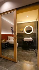 a bathroom with a sink and a toilet and a bed at Hotel City Keys By Rivido, Electronic City in Bangalore