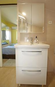 a white bathroom with a sink and a bedroom at Villa Tea in Donje Polje