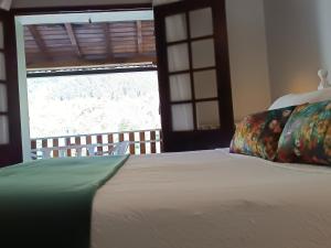 een slaapkamer met een bed en een groot raam bij São Miguel do Gerês in Geres