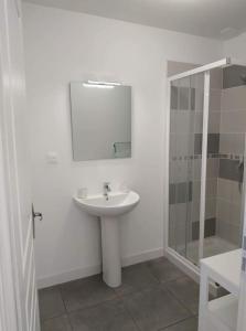 a white bathroom with a sink and a shower at Maison Rose-Trémière avec jardin clos - Plage à 500m in Chaucre