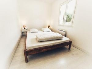 a bed in a white room with a window at Maison Rose-Trémière avec jardin clos - Plage à 500m in Chaucre