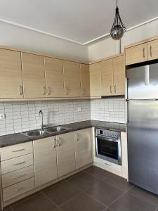 a kitchen with wooden cabinets and a stainless steel refrigerator at EVa's Luxury Apartments No 2 in Áyios Spirídhon