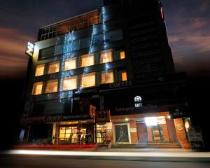 un edificio alto con luces encendidas por la noche en Hotel City Keys By Rivido, Electronic City, en Bangalore