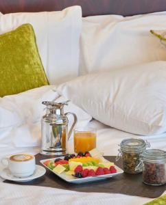 Mardin Hotel Novxanı في باكو: صينية الافطار مع الفاكهة والعصير على السرير