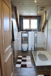 uma casa de banho com uma cabina de duche em vidro e um WC. em Landhaus Kranzbichl em Berchtesgaden