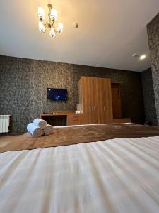 a bedroom with a bed with two towels on it at Mardin Hotel Novxanı in Baku