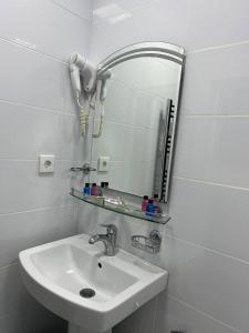 een badkamer met een wastafel en een spiegel bij Mardin Hotel Novxanı in Baku