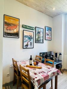 ein Esszimmer mit einem Tisch und einigen Bildern an der Wand in der Unterkunft Studio Endroit chaleureux au cœur des montagnes in Argelès-Gazost