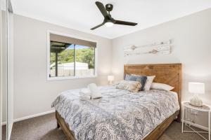 een slaapkamer met een bed en een plafondventilator bij Fraser Island Beach Houses in Fraser Island