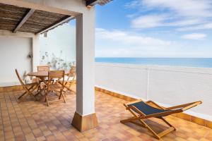 a balcony with a table and chairs and the ocean at Rooftop front de mer in Saint-Cyprien +17 photos