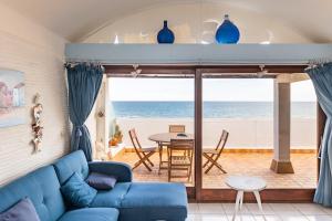 a living room with a blue couch and a view of the ocean at Rooftop front de mer in Saint-Cyprien