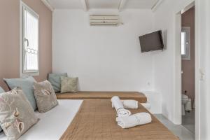 een witte kamer met een bed met handdoeken erop bij Ninemia Suites Tinos Superior 201 in Kionia