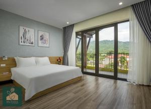 sypialnia z dużym łóżkiem i dużym oknem w obiekcie Ms Taha Villas Ba Vi - Venuestay w mieście Ba Vì District