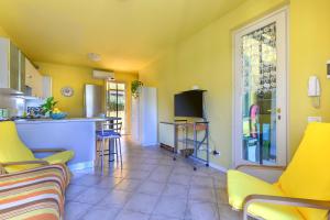 uma cozinha e sala de estar com paredes amarelas em Casa Minnie em Cavo