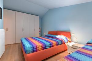 um quarto com uma cama laranja e um cobertor colorido em Casa Minnie em Cavo