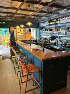 a bar with chairs and a counter in a restaurant at Bugler Doyles Bar & Townhouse in Wexford