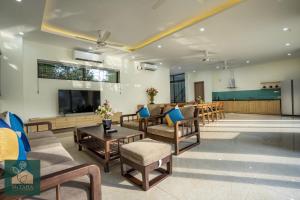 a living room with chairs and a tv and a table at Ms Taha Villas Ba Vi - Venuestay in Ba Vì