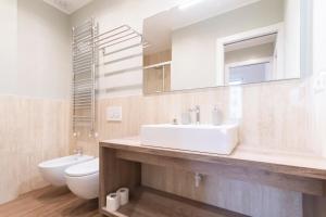 米兰Missori Apartment 1的浴室里有洗手池、马桶和镜子。 更多16张照片