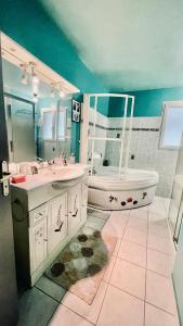 een badkamer met een bad, een wastafel en een bad bij Maison spacieuse à deux pas de la plage in Roscanvel