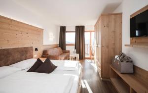 a hotel room with a bed and a television at Hotel Fernblick in Bressanone