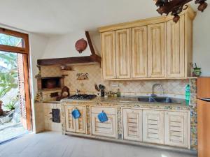 a kitchen with wooden cabinets and a sink at Cynara holiday house in Massa Lubrense