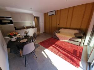 uma sala de estar com uma mesa e uma cozinha em Magnifique studio au bord du lac du Bourget à proximité d'Aix-les-Bains em Tresserves