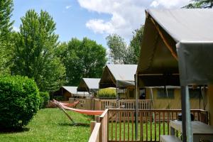 un grupo de lodges con hamaca y parque infantil en Glamping Dordogne, en Douville