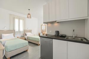 uma cozinha com duas camas e um lavatório num quarto em Vive Mare Plaka II em Naxos Chora