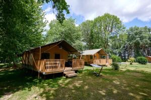 Cabaña de madera con porche y columpio en Glamping Dordogne, en Douville