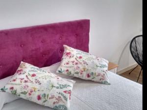 2 almohadas en una cama con cabecero púrpura en Apartment 2 Bedrooms 8951, en Bosquemado