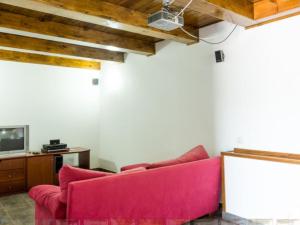 a living room with a red couch and a tv at Apartment 2 Bedrooms 8951 in Bosquemado